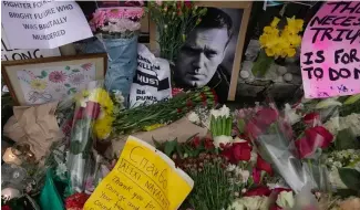  ?? ?? FILE - Flowers and portraits are left opposite the Russian embassy, to commemorat­e the death of Alexei Navalny in London, Monday, Feb. 19, 2024.