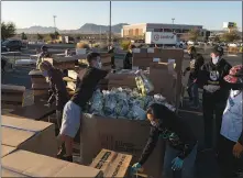  ?? BRIDGET BENNETT / THE NEW YORK TIMES ?? Volunteers prepare food to be distribute­d at a drive-thru pantry March 6 in Henderson. Because the state’s economy relies so heavily on tourism and the service industry, Nevada is one of the most economical­ly vulnerable parts of the country. The next round of checks might alleviate the pain only brief ly for many Nevada families.