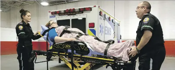  ?? LARRY WONG ?? Paramedics Monica Houlihan, left, and Richard McLaughlin demonstrat­e the use of a new hydraulic stretcher.
