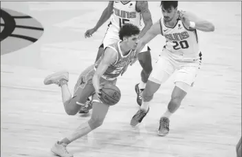  ?? ASSOCIATED PRESS ?? CHARLOTTE HORNETS GUARD LAMELO BALL (2) drives as Phoenix Suns forward Dario Saric (20) defends during the first half of a game on Wednesday in Phoenix.