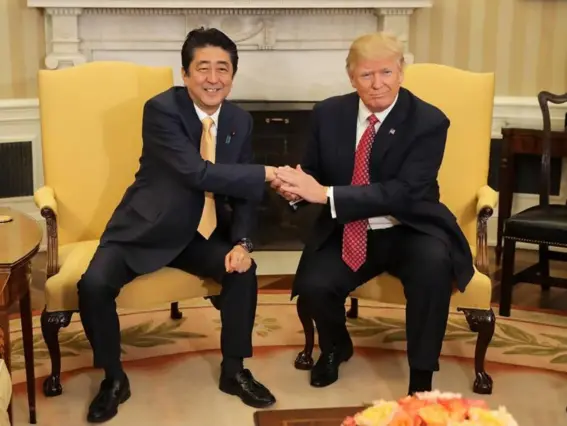  ?? (EPA) ?? Patting down: the Donald held Japanese PM Shinzo Abe’s hand for a gruelling 19 seconds