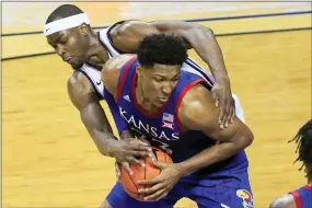  ?? ORLIN WAGNER — THE ASSOCIATED PRESS ?? Kansas forward David McCormack (33) is fouled by Kansas State forward Makol Mawien, left, during the second half of last Saturday’s game in Manhattan, Kan. The Jayhawks held on for a 62-58victory.