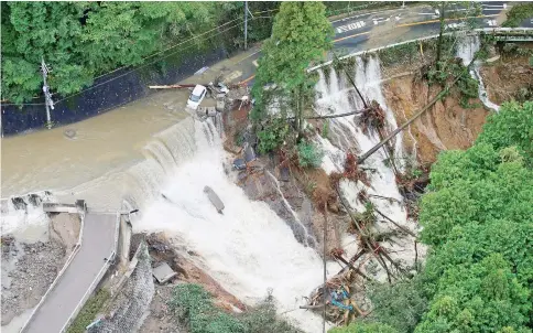  ??  ?? A collapsed road is seen following torrential rain caused by typhoon Lan in Kishiwada. — Reuters photo