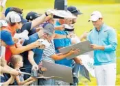  ?? GREGORY SHAMUS/GETTY IMAGES ?? Rory McIlroy signs autographs during a practice round on Tuesday for the 2017 U.S. Open at Erin Hills.