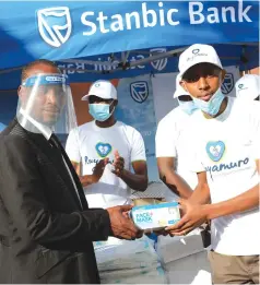  ?? Picture: Tinai Nyadzayo ?? Stanbic Bank Mutare branch manager, Mr Lincoln Mhlanga (right) hands over personal protective material for Mutare Infectious Diseases Hospital to City of Mutare Mayor, Councillor Blessing Tandi (left) on Wednesday.—