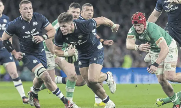  ?? ?? Huw Jones on the charge against Ireland in Dublin last weekend – but he injured the ring finger on his right hand just before half-time