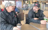  ?? JEREMY FRASER/CAPE BRETON POST ?? Transport drivers Raymond Surette, left, and Romeo Allain are shown chatting and having a coffee at the Tim Hortons outlet in North Sydney, Wednesday. The truck drivers, both heading to Newfoundla­nd, have been stuck in North Sydney with ferry crossings being cancelled due to high winds.