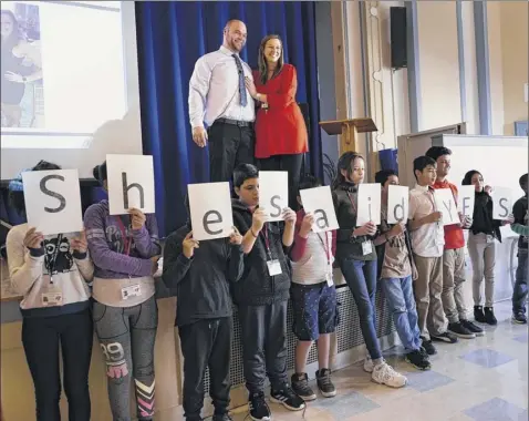  ?? Photos by Paul Buckowski / times union ?? terry Burke and his girlfriend, Christina Zontini, a sixth grade teacher at Albany internatio­nal Center school, pose with students holding lettered prints stating, “she said yes,” in Zontini’s class after Burke proposed to her on thursday.