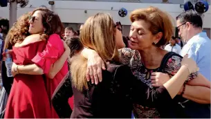  ??  ?? HUGS OF HAPPINESS... People greet each other at the St.Mary’s Church on Christmas Day.