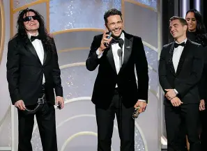  ?? Paul Drinkwater/NBC via AP ?? This image released by NBC shows James Franco, center, accepting the award for best actor in a motion picture comedy or musical for his role in "The Disaster Artist," as Tommy Wiseau, left, and brother Dave Franco look on Jan. 7 at the 75th Annual...