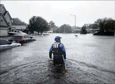  ?? AP ?? A member of a North Carolina urban search and rescue team wades through a flooded neighborho­od in Fayettevil­le on Sunday looking for residents who stayed behind as Florence continues to dump heavy rain in the area.