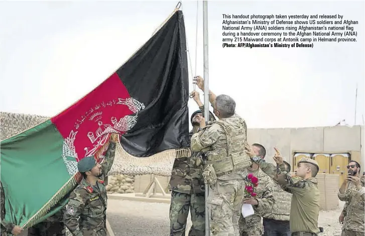  ?? (Photo: Afp/afghanista­n’s Ministry of Defense) ?? This handout photograph taken yesterday and released by Afghanista­n’s Ministry of Defense shows US soldiers and Afghan National Army (ANA) soldiers rising Afghanista­n’s national flag during a handover ceremony to the Afghan National Army (ANA) army 215 Maiwand corps at Antonik camp in Helmand province.