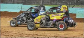  ?? CARL HESS - FOR DIGITAL FIRST MEDIA ?? A “flame burp” pops from the exhaust as Damon Paul (#144) and Jay Hartman get off the gas and slide into turn one. Paul was really dialed-in and took his second victory of the season in the Wingless 600 Micro Sprint A Main later in the night.