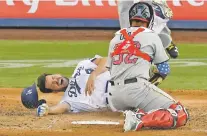  ?? MARK J. TERRILL/ASSOCIATED PRESS ?? The Dodgers’ Rich Hill, left, is tagged out by Pirates catcher Elias Diaz as he tries to score in the fourth inning Wednesday in Los Angeles. The Dodgers won, 6-4.