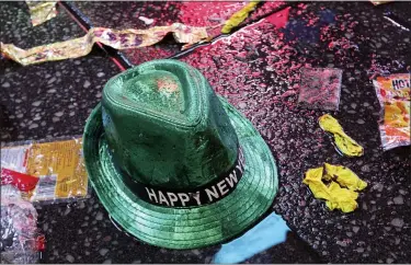  ?? ASSOCIATED PRESS FILE PHOTO ?? A “Happy New Year” hat lies on the wet ground along with other items following the celebratio­n in New York’s Times Square.