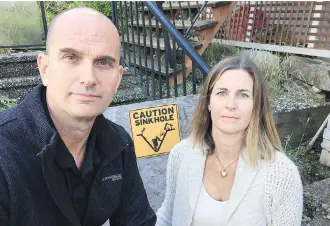  ?? RANDY SHORE ?? Ross and Erin Storey are paying a mortgage on a house they can’t set foot in after a sinkhole opened up in their front yard in Sechelt. They’re suing the developer, engineerin­g firms and the municipali­ty.