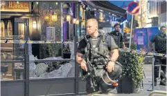  ?? ?? ‘ACT OF TERRORISM’: Security forces stand at the site where several people were injured during a shooting outside the London Pub in central Oslo yesterday.