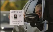  ??  ?? Lee Bellus, of Oley, holds a sign that reads “God’s gift to us!! Congratula­tions on your 60th” during a drive-thru tribute to Monsignor James Treston on May 14at St. Catharine of Siena Catholic Church in Exeter Township.