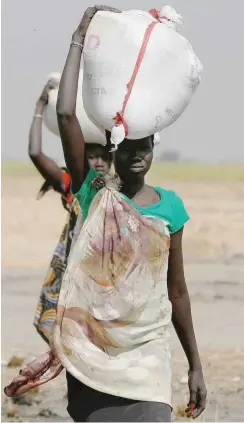  ?? Foto: reuters/Siegfried Modola ?? Frauen in Südsudan tragen Säcke mit Getreide