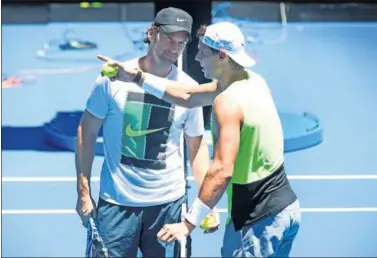  ??  ?? TÁNDEM. Carlos Moyá y Rafa Nadal conversan durante el entrenamie­nto de ayer en Melbourne.