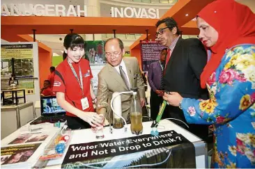  ??  ?? Solving water woes: (From left) Teng explaining how her water filter works to Madius, his deputy Datuk Dr Abu Bakar Mohamad Diah and Mosti Services and Developmen­t secretary Lailah Mohd Che Darus when they visited her booth.