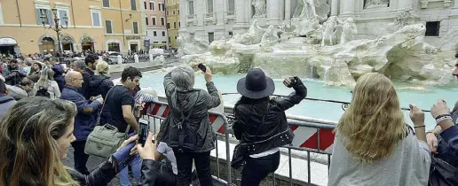  ??  ?? Il lancio Turisti lanciano le monetine nella Fontana di Trevi: si dice che faccia tornare a Roma (foto Corradetti/ LaPresse)