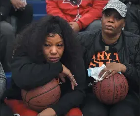  ?? PETE BANNAN — MEDIANEWS GROUP ?? Nikera Brooks, left, mother of murdered Chester player Edward Harmon, and her mother Lisa Brooks, hold signed basketball­s presented by Chester players before the start of their PIAA playoff game against Simon Gratz Wednesday evening at Cardinal O’Hara.