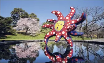  ??  ?? The sculpture “I Want to Fly to the Universe” by Japanese artist Yayoi Kusama is reflected in a pool at the New York Botanical Garden on April 8.