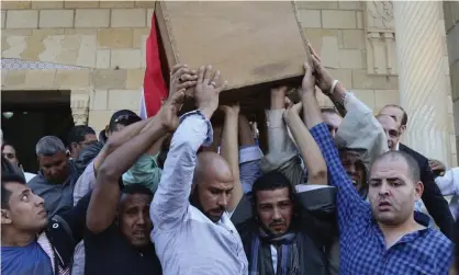  ??  ?? People carry the coffin of police captain Ahmed Fayez, who was killed in the gun battle in Giza province. Photograph: Alaa Elkassas/AP