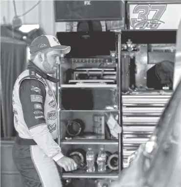  ?? THE ASSOCIATED PRESS ?? Chris Buescher looks over his car in the garage after practice for today’s NASCAR Cup Series race at Pocono Raceway. Buescher surprised everyone when he won last year’s rain-shortened Pocono 400.