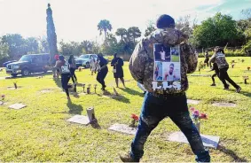  ?? CRAIG BAILEY/FLORIDA TODAY ?? Spectators run from the scene after a shot was fired during the burial service of Sincere Pierce at Riverview Memorial Gardens in Cocoa, Florida, on Saturday. Pierce was one of two teens shot and killed by a Brevard County sheriff’s deputy on Nov. 13.