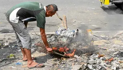  ?? —KRISTINE ANGELI SABILLO/INQUIRER.NET ?? TOXIC WORK Black smoke rises from a pile of burning copper wire, a commodity sought after by scavengers and junk shop owners.