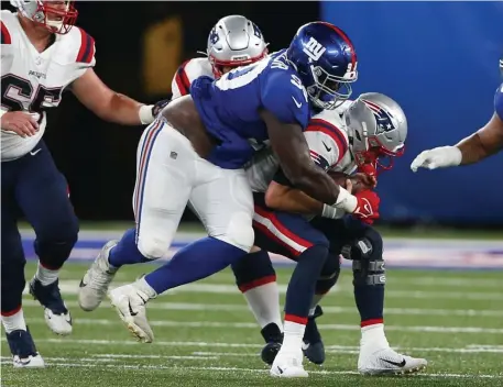  ?? Ap FIle pHotos ?? BRINGING THE HEAT: Patriots rookie quarterbac­k Mac Jones is sacked by Giants defensive lineman Willie Henry on Aug. 29 in East Rutherford, N.J. Below, Jones is pressured by Giants linebacker Lorenzo Carter, left.