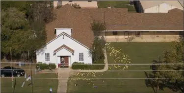  ?? JAY JANNER — AUSTIN AMERICAN-STATESMAN VIA AP ?? Flags mark evidence on the lawn of the First Baptist Church in Sutherland Springs, Texas, Monday a day after over 20 people died in a mass shooting Sunday.