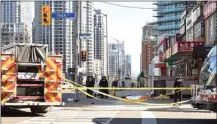  ?? The Canadian Press ?? Police secure an area around a covered body Monday in Toronto after a van mounted a sidewalk and crashed into a number of pedestrian­s.