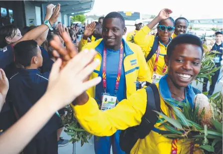  ?? Picture: CHRIS HYDE/GETTY ?? Rwandan athletes are cheered as they arrive at Livingston­e Christian College yesterday.