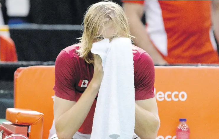  ?? — THE CANADIAN PRESS ?? Denis Shapovalov covers his face with a towel after he defaulted his Davis Cup tie match for accidental­ly hitting the chair umpire with a ball on Sunday.