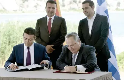  ?? AFP ?? Greek Foreign Minister Nikos Kotzias (R) and his Macedonian counterpar­t Nikola Dimitrov (L) sign a preliminar­y accord as Greek Prime Minister Alexis Tsipras (R) and Macedonian Prime Minister Zoran Zaesign stand during a ceremony at Prespes Lake on Sunday. —