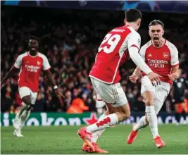  ?? (AFP) ?? Arsenal’s Leandro Trossard (right) celebrates after scoring the equaliser against Bayern Munich during the Champions League quarter-final first leg match in London yesterday.