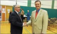  ?? GLENN GRIFFITH — GGRIFFITH@DIGITALFIR­STMEDIA.COM ?? Shen Board of Education President Bill Casey, left, shakes hands with Clifton Park Supervisor Philip Barrett, right, after the votes were tallied at a public referendum on selling 34 surplus acres of district land to the town.