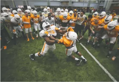  ?? DONALD PAGE/TENNESSEE ATHLETICS ?? Tennessee offensive lineman Trey Smith and defensive lineman Paul Bain grapple while the rest of the Vols watch during last Thursday’s spring practice. Smith graduated from high school one semester early and missed the Vols’ first spring scrimmage to...