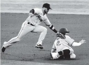  ??  ?? Marlins second baseman Eddy Alvarez tags out Toronto’s Travis Shaw during the first inning Wednesday.