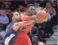  ?? CHARLES REX ARBOGAST/AP ?? The Nuggets’ Trey Lyles, left, knocks the ball away from the Bulls’ Bobby Portis.