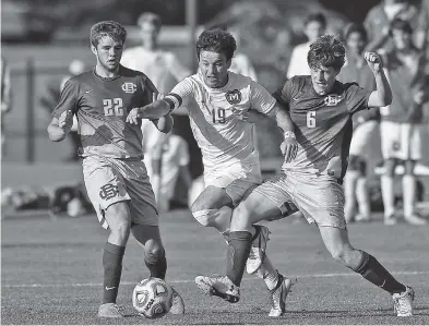  ?? STAFF PHOTO BY DOUG STRICKLAND ?? McCallie’s Drew Viscomi, center, breaks through between Christian Brothers’ Jacob Bray, left, and Egan Webster during their Division II-AA soccer state semifinal Wednesday in Murfreesbo­ro. McCallie won 1-0.