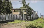  ?? (AP/Moses Sawasawa) ?? Rwandan security forces look out from their sentry box as Congolese soldiers patrol on foot on their side of the Petite Barriere border crossing with Rwanda Friday in Goma, eastern Congo.