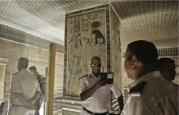  ?? NARIMAN EL-MOFTY/THE ASSOCIATED PRESS ?? A police officer takes a selfie at the Amenhotep II tomb in the Valley of the Kings in Luxor, Egypt. Minister Mamdouh el-Damaty said he is seeking approval for radar inspection of Tut’s tomb.