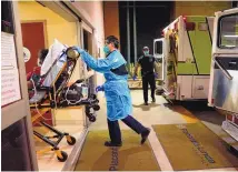  ?? JAE C. HONG/ASSOCIATED PRESS ?? An emergency medical tech pushes a gurney into an emergency room to drop off a COVID-19 patient in California in January. Cases in the U.S. are falling, but deaths remain high.