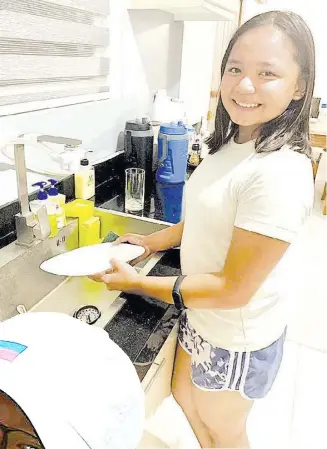  ?? PHOTOGRAPH­S COURTESY OF RIANNE MIKHAELA MALIXI ?? RIANNE Mikhaela Malixi washes dishes at home as part of her training in golf and in life.