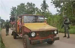  ??  ?? Philippine marines check a passenger jeepney at a check point in Indanan town in Sulu province on the southern island of Mindanao