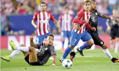  ?? Photo: Getty Images ?? Antoine Griezmann of Atletico Madrid battles for the ball with Arturo Vidal and Thiago of Bayern Muenchen during the UEFA Champions League group D match at the Vicente Calderon Stadium on September 28, 2016 in Madrid, Spain.